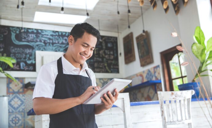 man smiling while holding a tablet