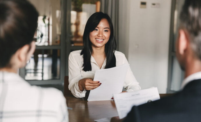 Filipina business owner in a loan interview, talking to two lenders