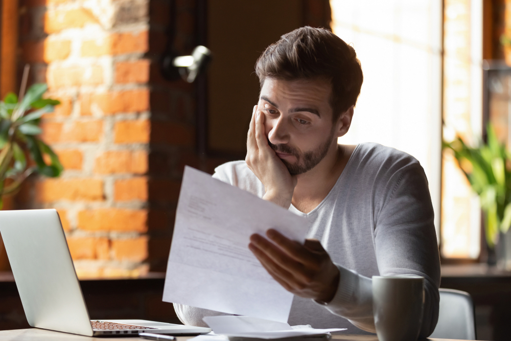 confused, frustrated young man, reading letter in cafe, debt notification